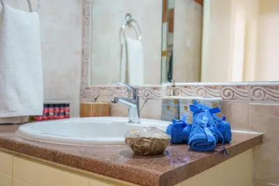 a bathroom with a sink and a tub with blue towels at The Valley Beyond in Paralimni