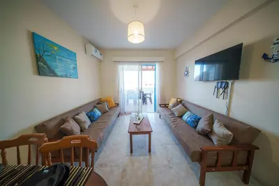 a living room with a long couch and a table at The Valley Beyond in Paralimni