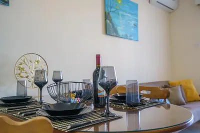 a dining room table with a bottle of wine and glasses at The Valley Beyond in Paralimni