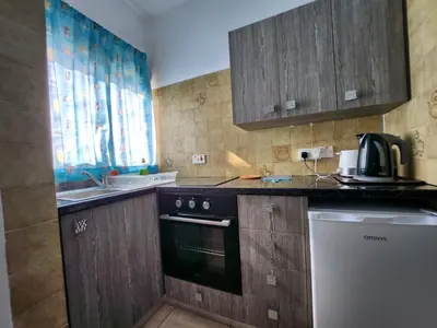 a kitchen with a black stove and a sink at Florence Hotel Apartments in Ayia Napa