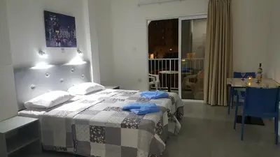 a bedroom with a bed and a table and a room at Florence Hotel Apartments in Ayia Napa