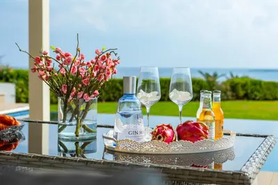 a table with wine bottles and glasses and flowers at Infinity Villa in Protaras