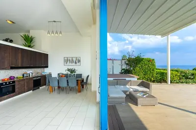 a kitchen and living room with a view of the ocean at Infinity Villa in Protaras