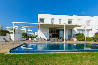 a villa with a swimming pool in front of a house at Infinity Villa in Protaras