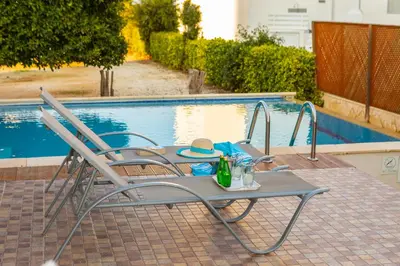 a table and chairs next to a swimming pool at Buena Vista Villa in Protaras