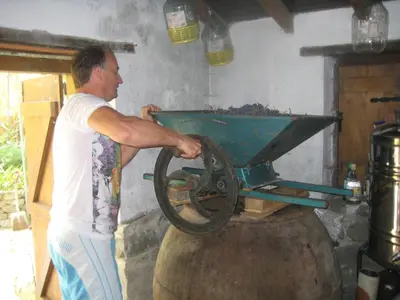 a man pushing a wheelbarrow on a barrel at Flora's House in Spilia