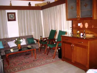 a living room with a couch and green chairs at Flora's House in Spilia