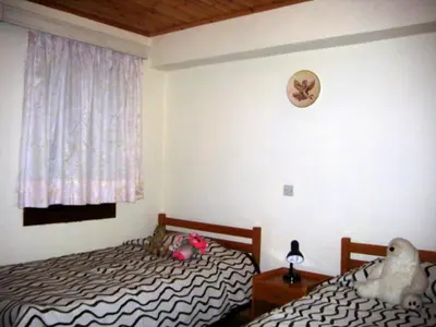 a bedroom with two twin beds and a window at Flora's House in Spilia