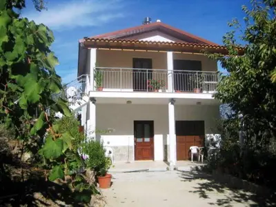 a large white house with a balcony on top of it at Flora's House in Spilia