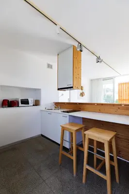a kitchen with two wooden stools and a counter at Art by PraXis in Governors Beach
