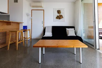 a bedroom with a bed and a wooden table at Art by PraXis in Governors Beach