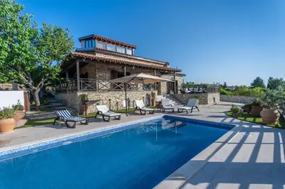 a swimming pool in front of a house at Lefkara Villa in Kato Lefkara
