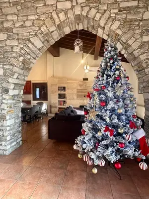 a christmas tree in a living room with a stone wall at Lefkara Villa in Kato Lefkara