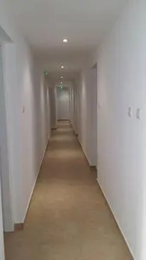an empty hallway with white walls and a long corridor at Simos Magic Hotel Apts in Ayia Napa