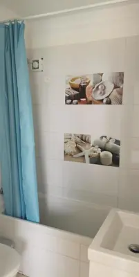 a bathroom with a blue shower curtain and a sink at Simos Magic Beach Hotel Apts in Ayia Napa