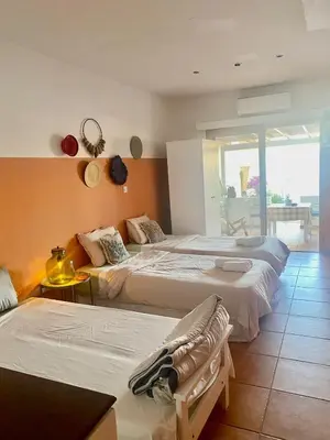 a hotel room with two beds and a balcony at Blue Peter Apartments in Protaras