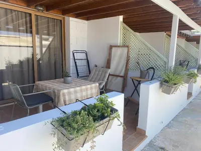 a patio with a table and chairs and plants at Blue Peter Apartments in Protaras