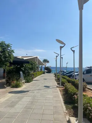 a sidewalk with street lights next to a parking lot at Blue Peter Apartments in Protaras