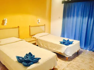 a room with two beds with blue flowers on them at Carina Hotel Apartments in Ayia Napa