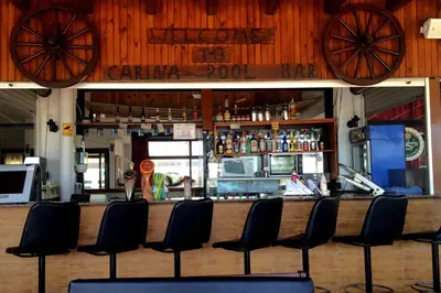 a bar in a restaurant with chairs in front of it at Carina Hotel Apartments in Ayia Napa