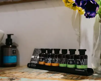 a group of four bottles of hair products next to a vase at Apanemia Inn Studio in Lofou