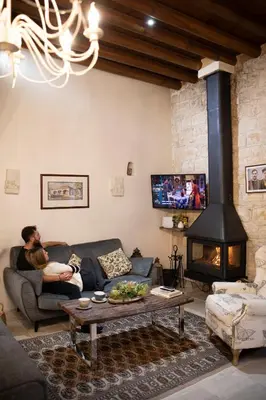 a man holding a baby in a living room with a fireplace at Apanemia Inn Studio in Lofou
