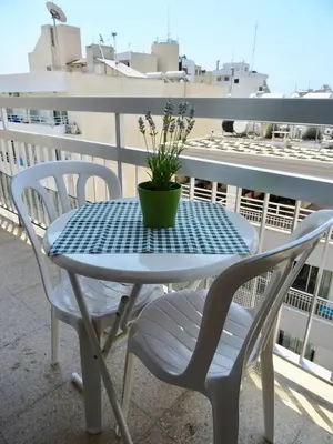 a table and chairs on a balcony with a potted plant at Camilla City apartment in Larnaka
