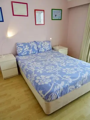 a bedroom with a bed with a blue comforter at Camilla City apartment in Larnaka