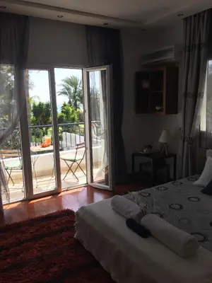 a bedroom with a bed and a sliding glass door at Deluxe First Line Villa in Pervolia