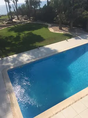 a large blue swimming pool in a yard at Deluxe First Line Villa in Pervolia