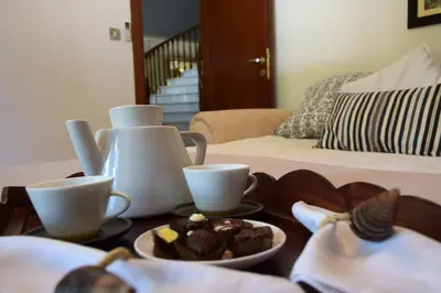 a table with two cups and a plate of cupcakes at Deluxe First Line Villa in Pervolia