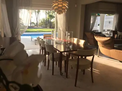 a dining table and chairs in a living room at Deluxe First Line Villa in Pervolia