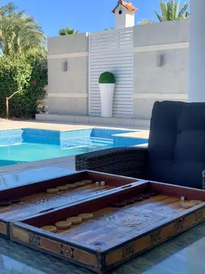 a pool with a couch and a chair next to it at Deluxe First Line Villa in Pervolia