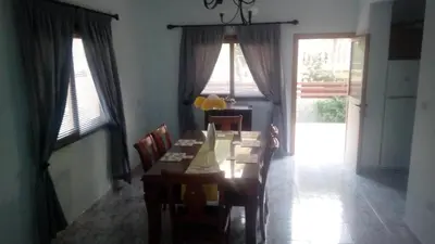 a dining room with a table and chairs and windows at House on the hill in Xylophaghou