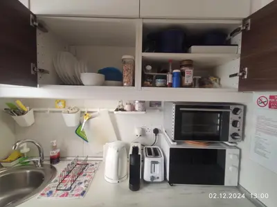 a kitchen counter with a microwave and a sink at Elena Holiday Apartment in Larnaka