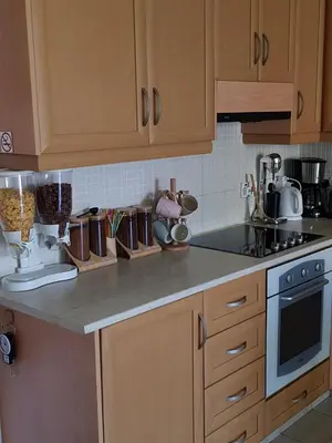 a kitchen with wooden cabinets and a counter top at Ria Court 33 in Larnaka