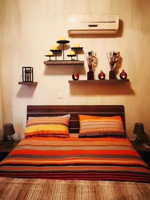 a bed with two pillows and shelves on the wall at Ria Court 33 in Larnaka