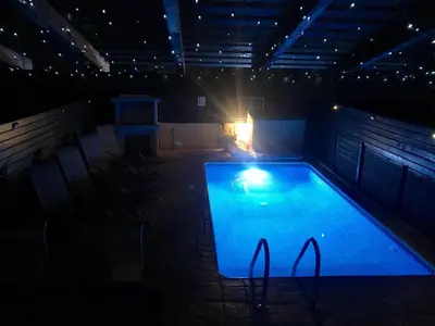 an empty swimming pool at night with a light in it at Villa Jade in Paralimni