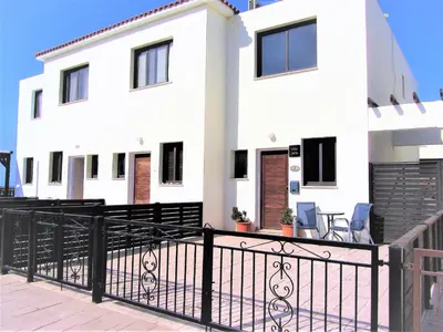 a white house with a black fence at Villa Jade in Paralimni