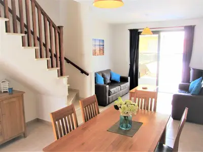 a dining room and living room with a table and chairs at Villa Jade in Paralimni