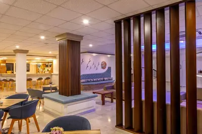 a restaurant with chairs and tables and a fireplace at Seagull Hotel Apartments in Protaras