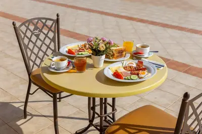 a yellow table with two plates of food on it at Seagull Hotel Apartments in Protaras