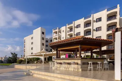 a building with a table and chairs in front of it at Seagull Hotel Apartments in Protaras
