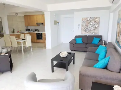a living room with two couches and a table at Haig's Dream Flat On The Beach in Larnaka