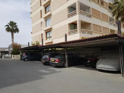 a parking lot with cars parked in front of a building at Haig's Dream Flat On The Beach in Larnaka