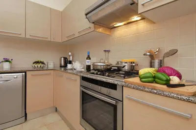a kitchen with a stove and a counter with vegetables at Villa Cleopatra in Ayia Napa