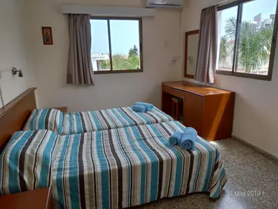 a bedroom with a bed and a dresser in it at Maricosta Apartments in Protaras