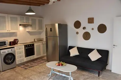 a living room with a couch and a kitchen at Athieno - Αθηαινώ in Athienou