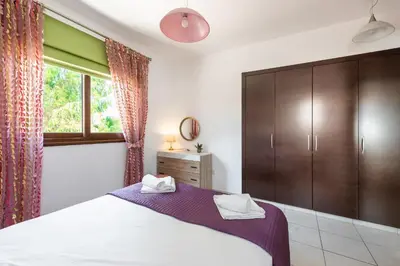 a bedroom with a large bed and a window at Sea Front Oceanus H3 by Ezoria Villas in Ayia Napa