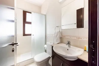 a bathroom with a white toilet and a sink at Sea Front Oceanus H3 by Ezoria Villas in Ayia Napa